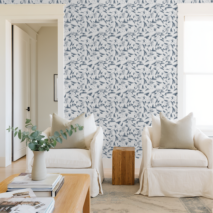 Blue dandelion and lily floral wallpaper in modern living room with white chairs.