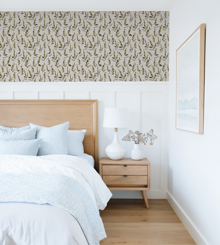 Leaf Whispers wallpaper in ivory and olive green in a modern bedroom with wooden furniture.