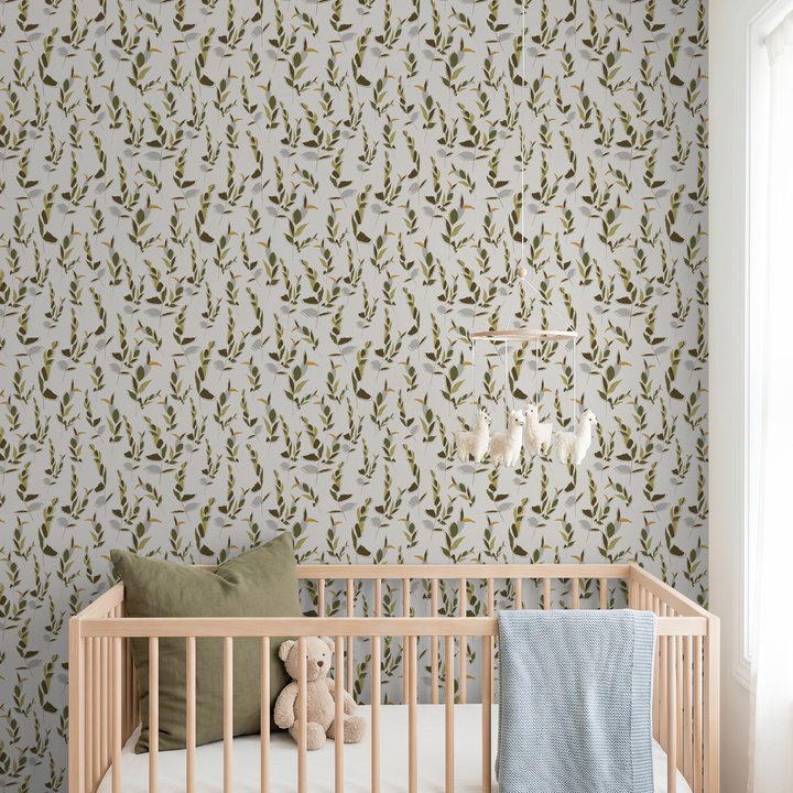 Ivory and olive green leaf pattern wallpaper in a cozy nursery with wooden crib.